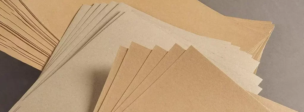 A stack of brown Kraft paper resting on a clean white background, showcasing its natural texture and color